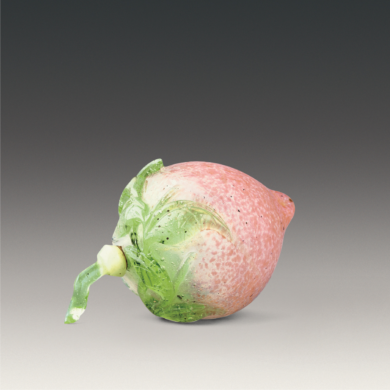 Peach-shaped snuff bottle in green overlay on pink ground